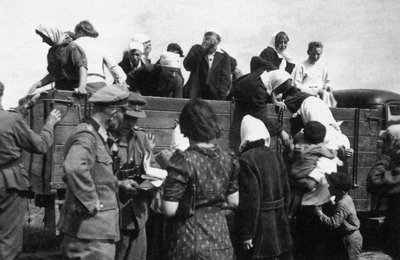 Historische schwarz-weiß Photographie von Zwangsarbeitern, welche auf einen Wagen geladen werden.