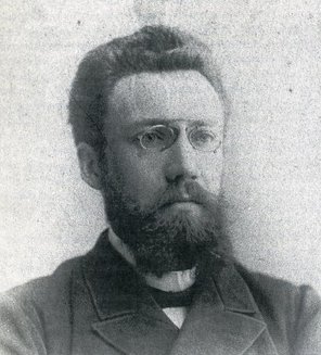 Portrait-Photographie von Karl Munzinger im mittleren Alter, mit Brille.